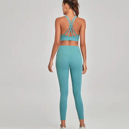 Person wearing a teal sports bra and leggings set on a gray background