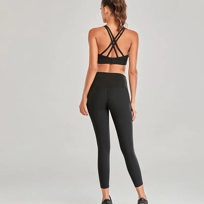 Person wearing a black sports bra and leggings set on a gray background