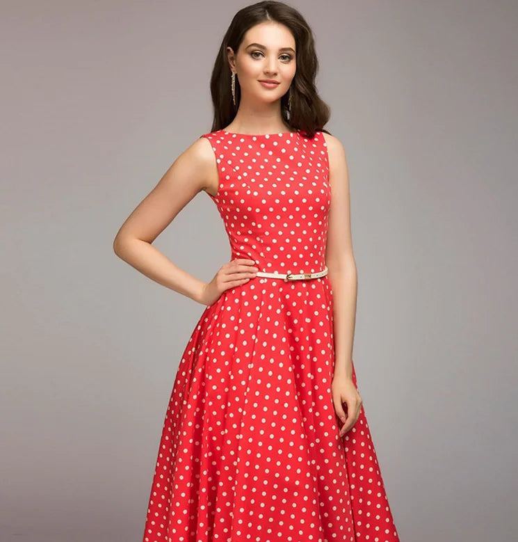 Woman wearing a red polka dot dress on a gray background