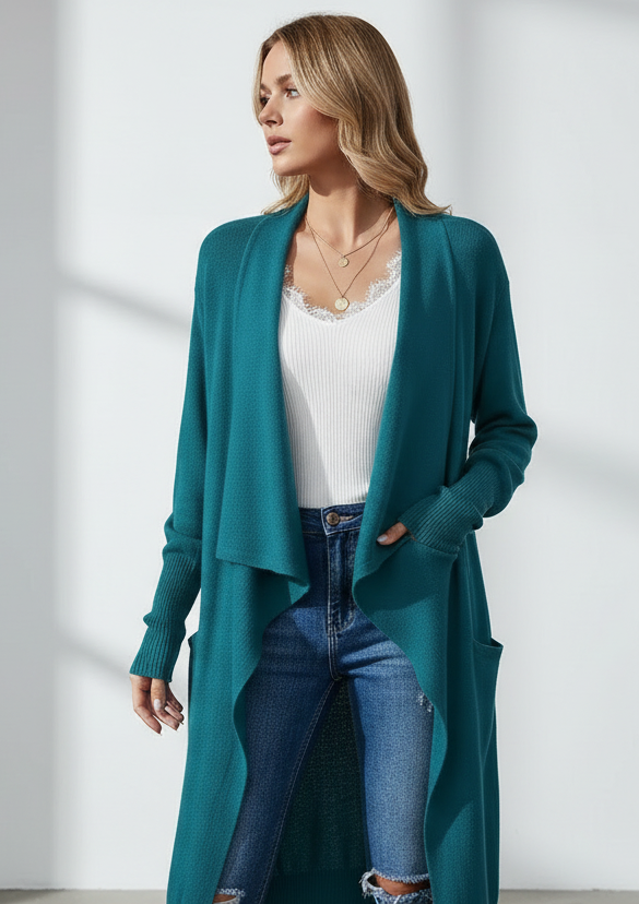 Woman wearing a teal cardigan, white top, and blue jeans against a white background