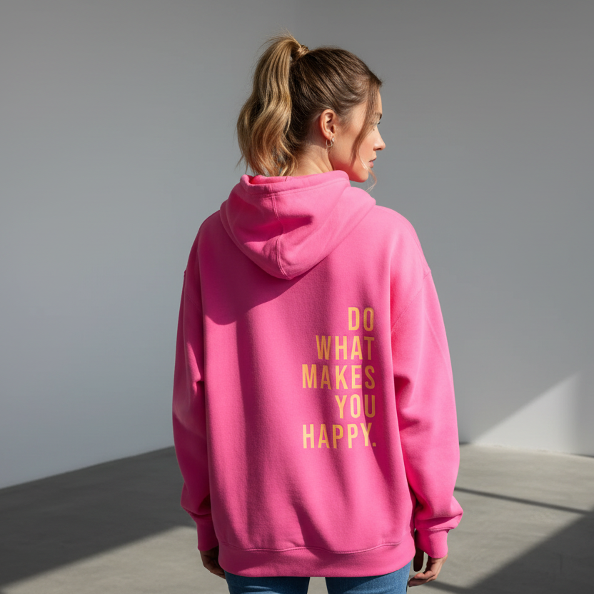 Person wearing a pink hoodie with a motivational quote on the back, standing against a neutral background.