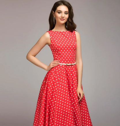Woman wearing a red polka dot dress on a gray background