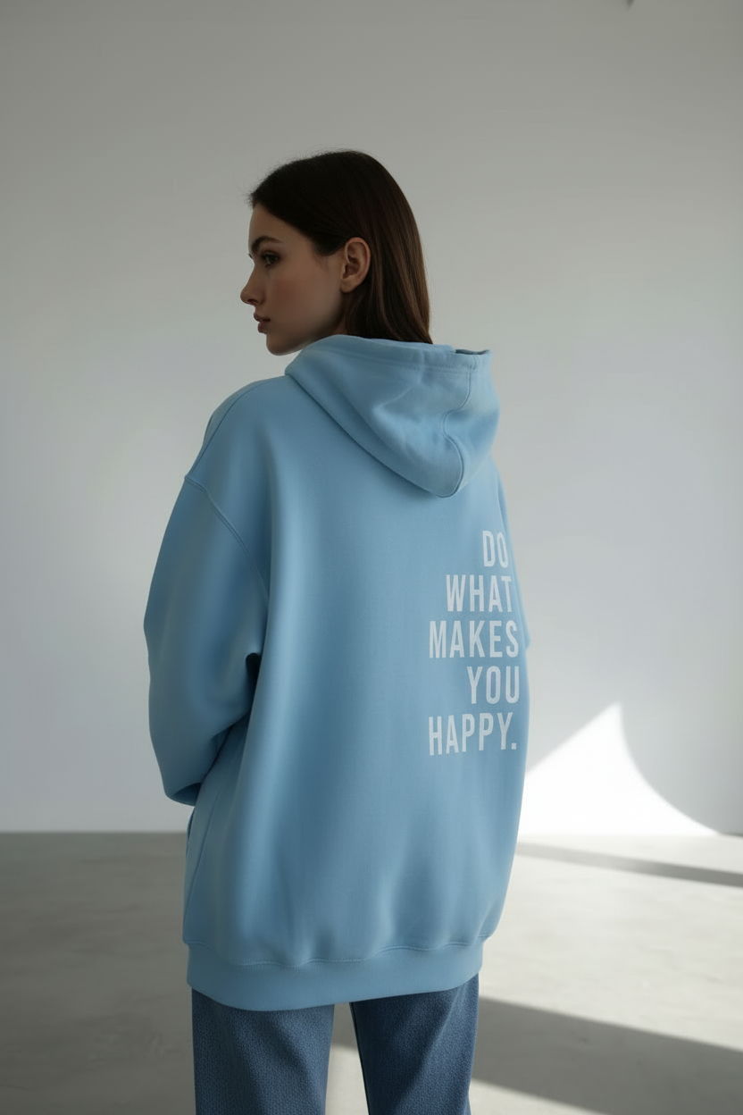 Person wearing a light blue hoodie with text on the back in a minimalistic setting
