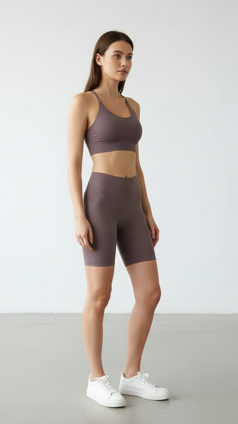 Woman wearing a brown athletic outfit with a white background