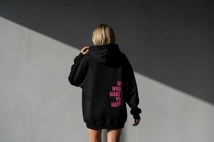 Person wearing a black hoodie with pink text on the back, standing against a gray background