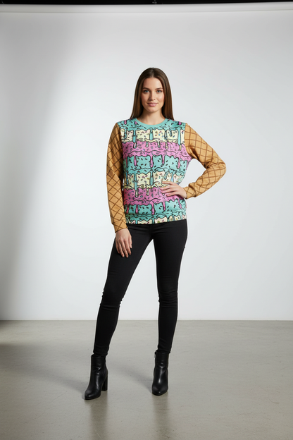 Woman wearing a colorful patterned top with black pants on a plain background