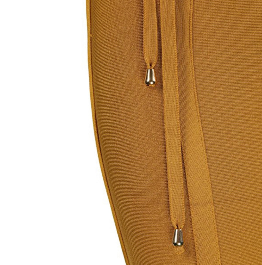 Close-up of a mustard yellow garment with a drawstring on a white background