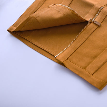 Close-up of a mustard yellow dress with a zipper on a light blue background