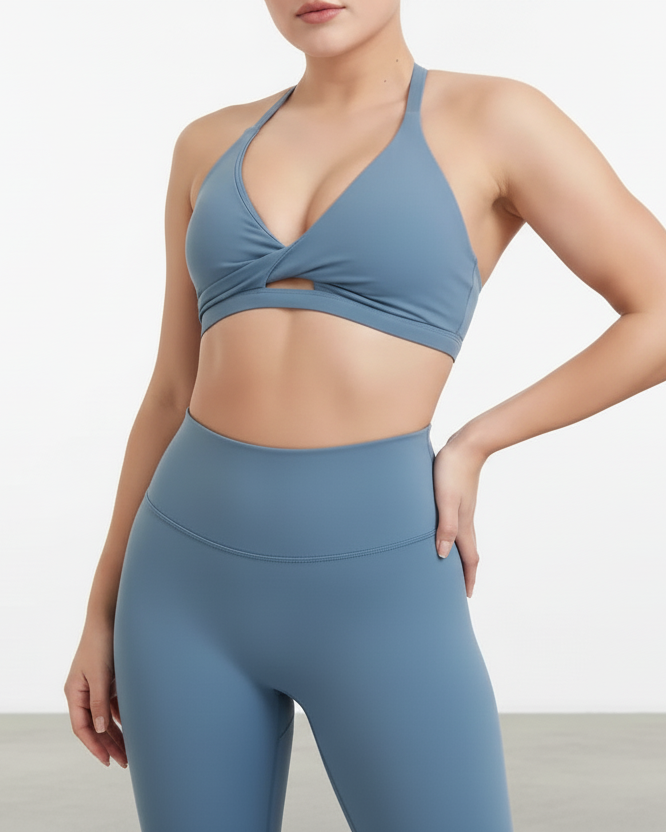 Woman wearing a blue sports bra and leggings on a white background